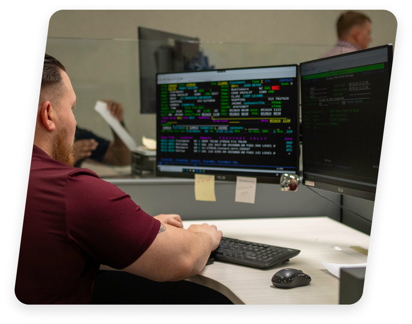 Employee at a freight carrier company in Claremont, NC analyzing data on computer screens.