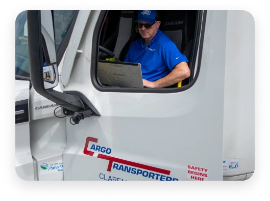 Professional driver in a Freightliner Cascadia truck, symbolizing reliable freight carrier services in the Greater Charlotte Area.