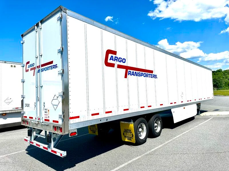 White freight truck labeled Cargo Transporters, representing transportation services in the Charlotte region, parked under clear blue sky.