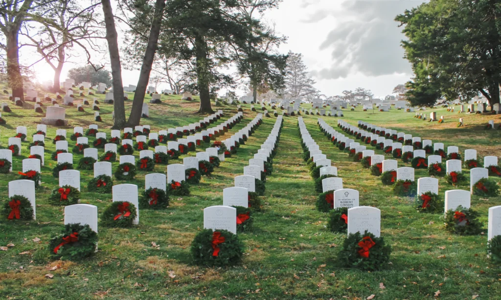 Rows of gravestones at a Charlotte cemetery adorned with holiday wreaths for Wreaths Across America, delivered by dedicated transport services.