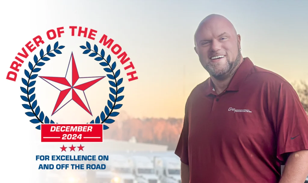 A.J. Quinn, December 2024 Driver of the Month for Cargo Transporters, stands in front of parked trucks near Charlotte NC.