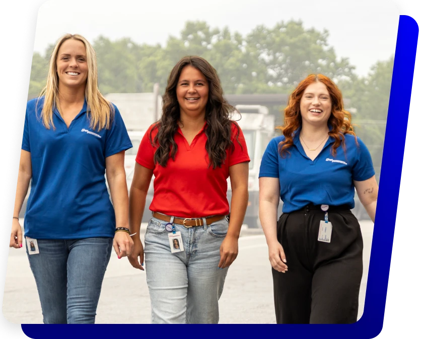 Three Cargo Transporters logistics team members walking outside Charlotte NC trucking terminal smiling in branded uniforms