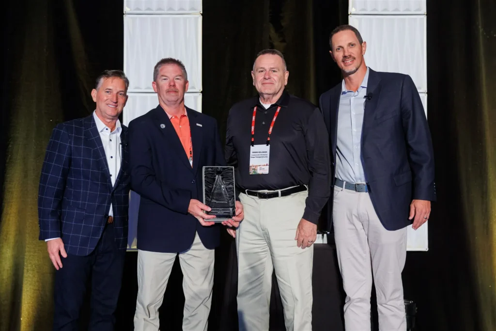Cargo Transporters leadership team receiving the 2025 WEX OTR Industry Ambassador Award on stage in San Antonio, Texas
